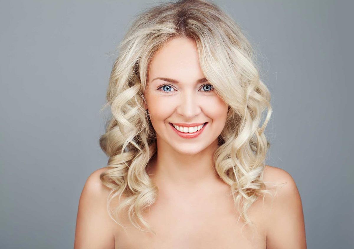 A happy woman in the grey background