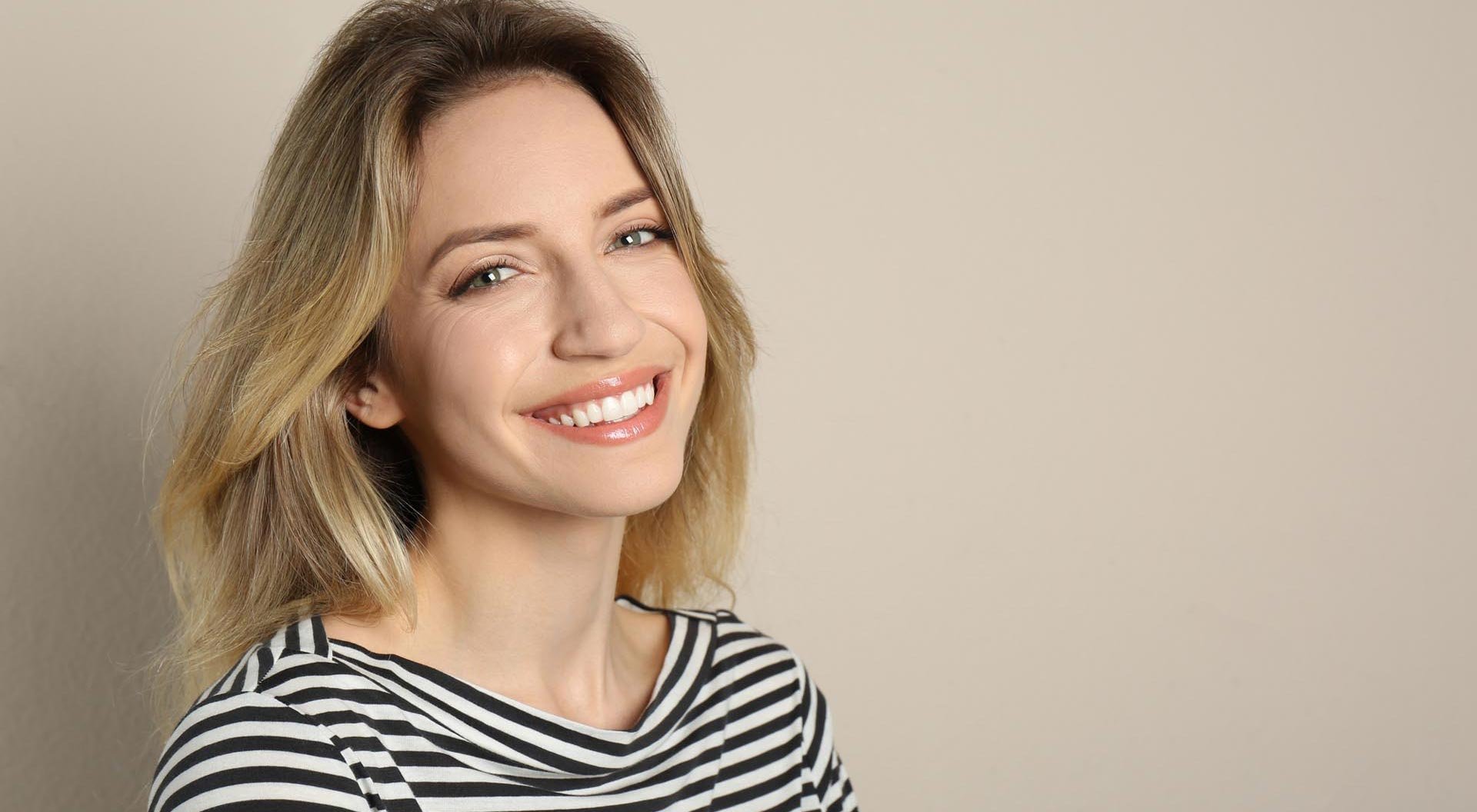 Portrait of happy young woman with beautiful blonde hair and charming smile
