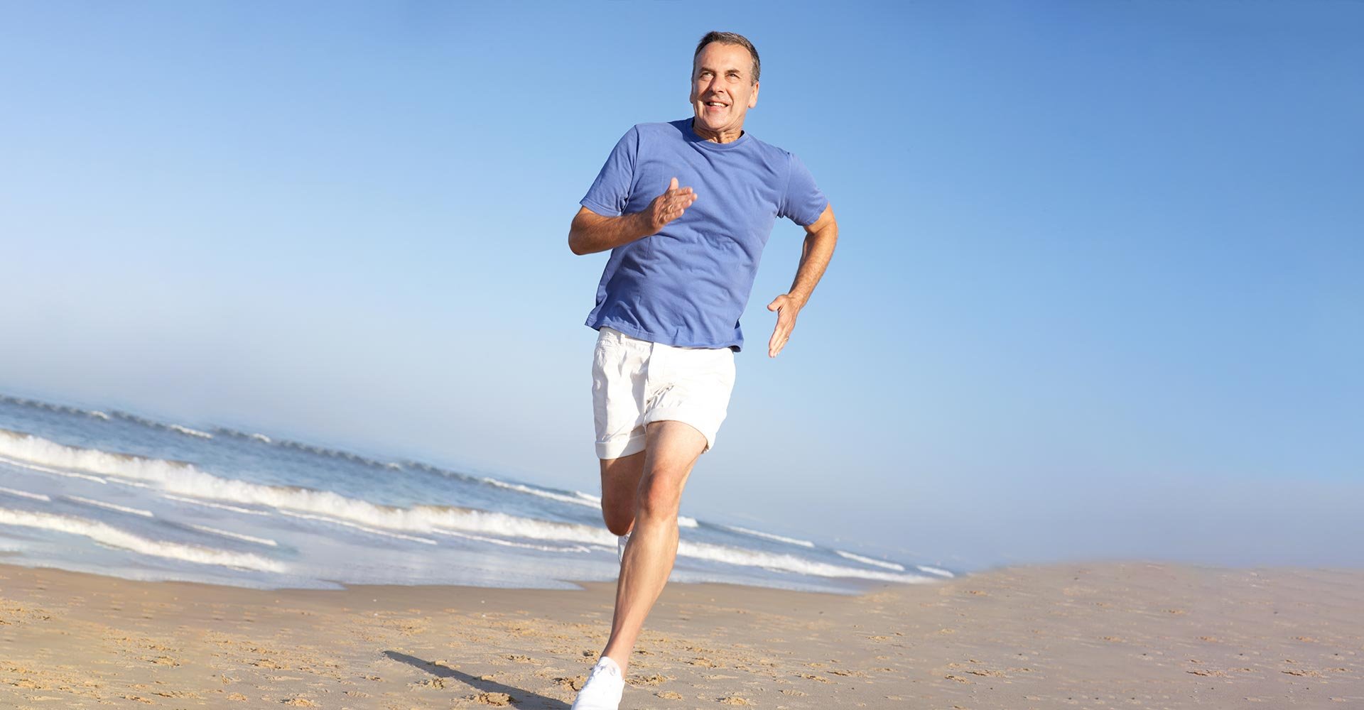 Senior Man Exercising On Beach