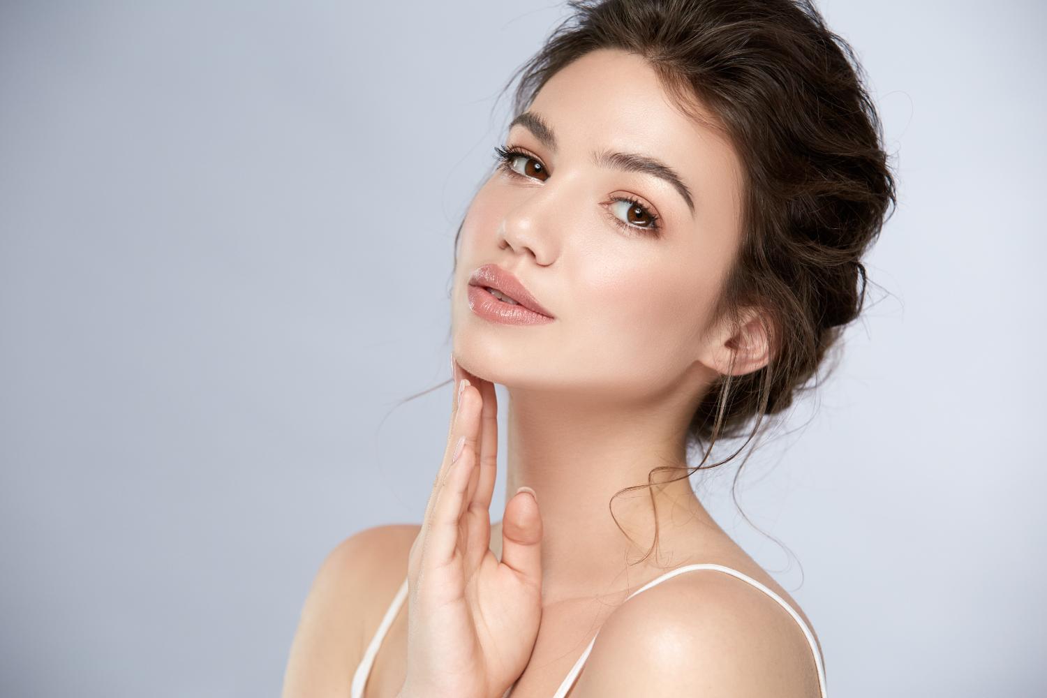 Woman touching her neck, highlighting plastic surgery results in Darien, CT